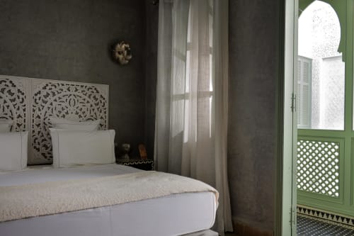 Chambre Royale slaapkamer in Riad Palau Marrakech met versierde hoofdeinde, groene luiken en traditioneel Marokkaans decor
