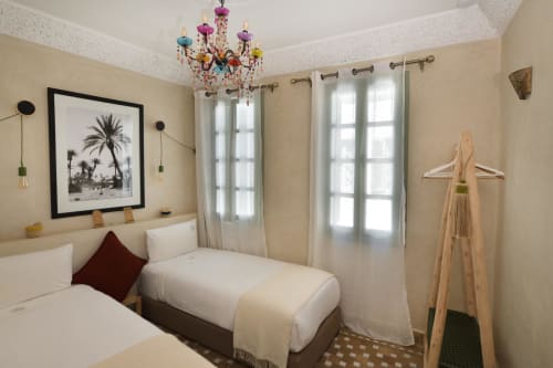 Kamer Essaouira in Riad Palau Marrakech: aparte bedden, gekleurde kroonluchter, palmboomkunstwerk, uitzicht op groene binnenplaats