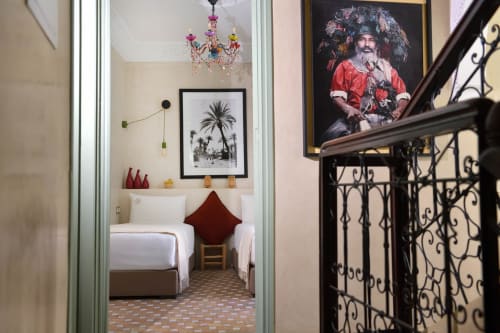 Essaouira slaapkamer in Riad Palau Marrakech met twee eenpersoonsbedden, kleurrijke kroonluchter en palmboomkunstwerk