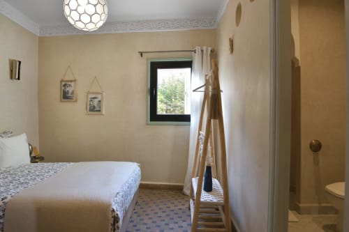 Chambre Blanche slaapkamer in Riad Palau Marrakech met bed, raam, houten ladder en en-suite badkamer