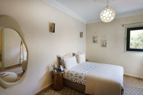 Chambre Blanche slaapkamer in Riad Palau Marrakech met queensize bed, rond hanglampje en boogvormige spiegel