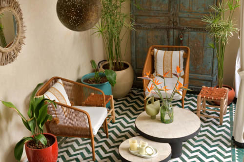 Buitenlounge van Riad Palau Marrakech met rieten stoelen, potplanten en decoratieve tafels in Marokkaanse riadstijl