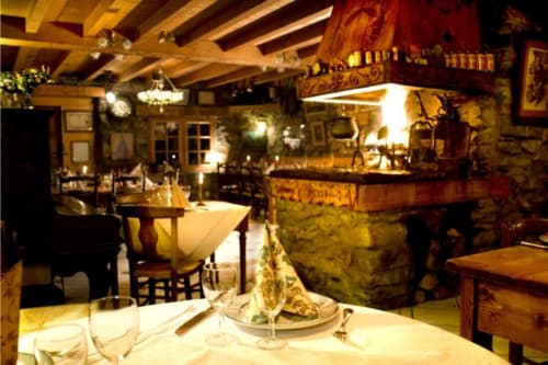 Auberge Nemoz dining room with fireplace, wooden beams, and candlelit tables in Le Haut-Bréda