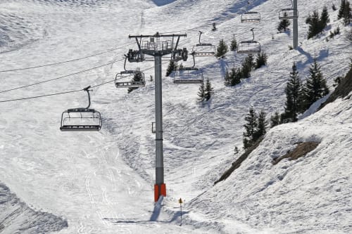 Ski lift over snowy slopes at Le Haut-Bréda near Auberge Nemoz, French Alps