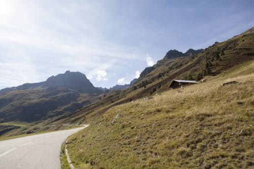 Alpine road leading to Auberge Nemoz in Le Haut-Bréda, France, surrounded by rolling mountains and pasture