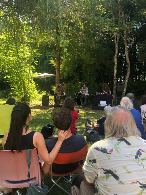Concert en plein air au Domaine de l'Ocrerie à Pourrain avec des invités profitant de la musique live sous les arbres