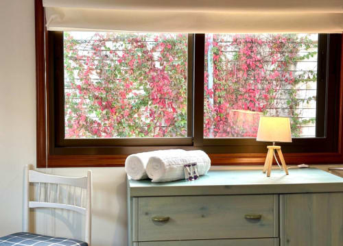 Apartamento en Baiona con vistas al mar, toallas blancas en el tocador, muebles de madera y bugambileas rosa en flor