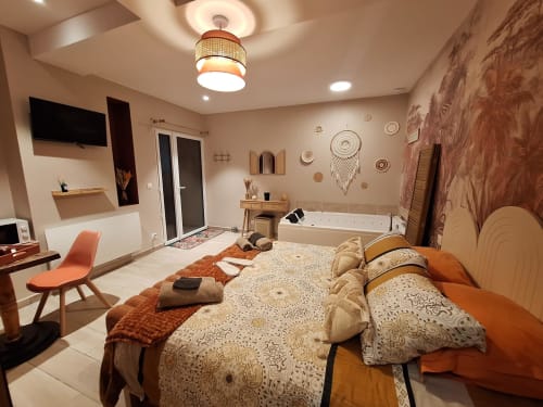 Chambre spacieuse à La Cour d'Hortense : lit queen-size, bain à remous, TV écran plat et décor moderne