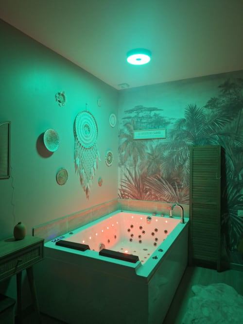 Spa avec baignoire turquoise à La Cour d'Hortense, fresque tropicale et attrape-rêve