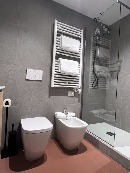 Bagno moderno a Casanova Hideaway Venezia con toilette, bidet, scaldasalviette e doccia walk-in