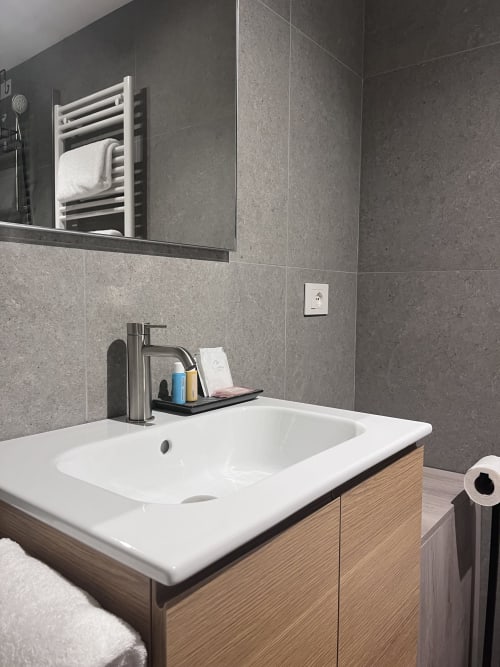Moderno lavabo e mobile bagno di Casanova Hideaway Venezia con piastrelle grigie e specchio
