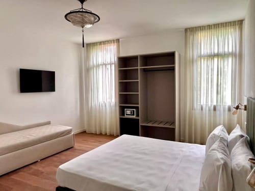 Camera Triple Superior spaziosa al Casanova Hideaway Venice con letto queen, zona salotto, armadio in legno scuro, TV e vista città