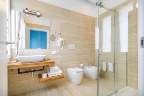 Modern bathroom at Bluemoon Sardinia in Cagliari with vessel sink, toilet, bidet, and walk-in shower