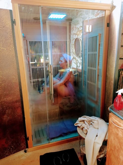 Modern glass shower cabin in CasaRosada wellness room, Vidracco Italy with blue lighting and decorative panels