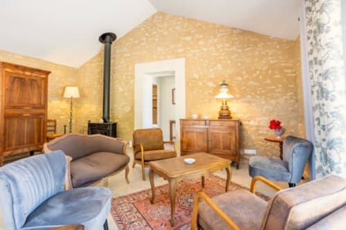 Salon rustique avec murs en pierre, mobilier en bois, cheminée et décoration française traditionnelle au Château de