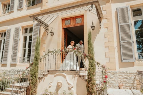 Couple sur un balcon de l'auberge La Maison Verneuil à Paray-le-Monial, architecture en pierre et lierre