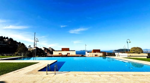 Piscina en Baiona con vistas al mar, tumbonas y arquitectura costera