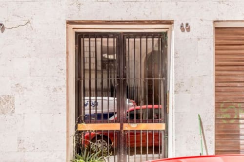 Ingresso della IV House B&B Roma con porte blindate e facciata consumata a Roma, Italia