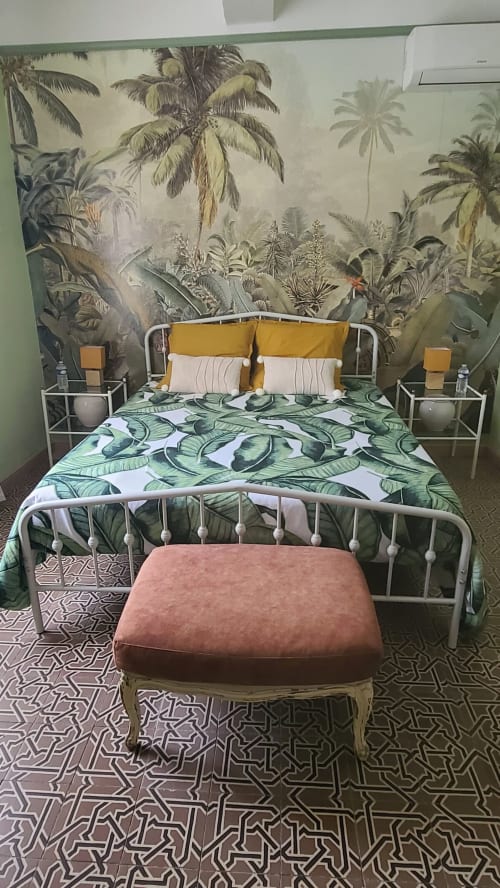 Chambre tropicale de la suite Carcassonne au Le N°9 B&B à Argeliers, avec fresque de palmiers et literie aux motifs de feuilles