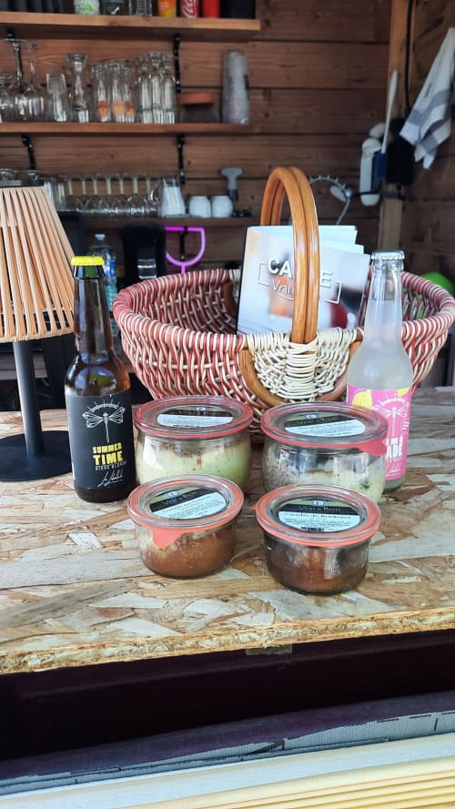 Panier en osier avec produits gourmands et bière à la réception du Home Sweet Lodge Glamping Aquitaine