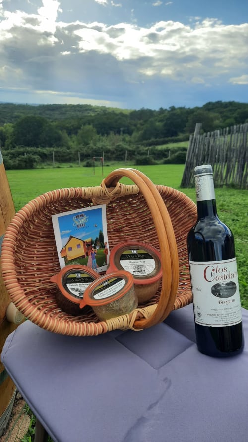 Panier de pique-nique français avec vin et fromages locaux dans la campagne d'Aquitaine au glamping Home Sweet Lodge