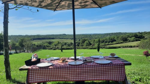 Espace repas en plein air sous parasol à Home Sweet Lodge Glamping Aquitaine avec vue sur la campagne vallonnée