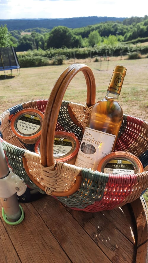 Panier pique-nique avec vin français et spécialités locales surplombant les vignobles du Home Sweet Lodge Glamping Aquitaine