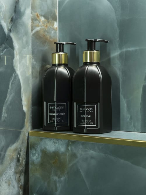Two black Dr. Vranjes luxury bottles with gold accents on marble shelf at YOUnique Boutique Rooms, Milano