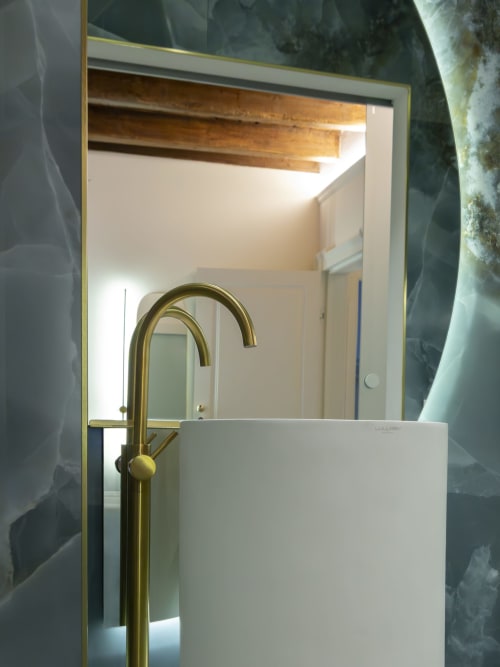 Modern bathroom sink with brass faucet and mirror in Moon River room at YOUnique Boutique Rooms, Milano