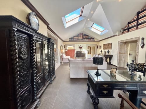 Interior elegante de villa histórica en Baiona con tragaluces, muebles negros ornamentados y comodidades modernas