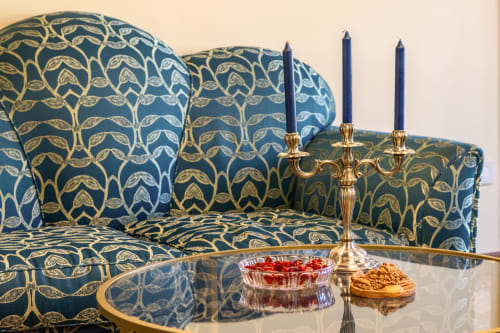 Suite veneziana lussuosa con divano a motivi blu e oro, candelabro in ottone e vista sul mare a Palazzo San Firmino