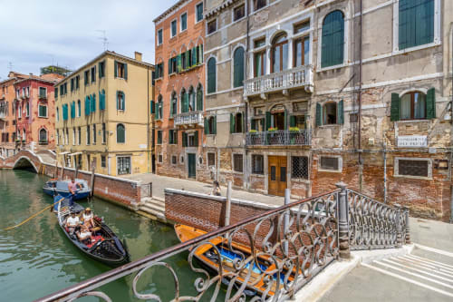 Palazzo veneziano con facciate colorate e gondole sul Canal Grande a Venezia, Italia