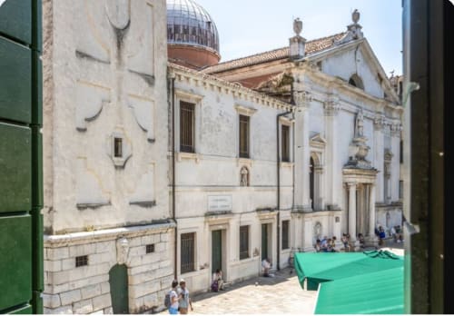 Corte storica del Palazzo San Firmino a Venezia con architettura neoclassica e persiane verdi