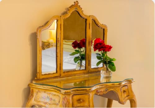 Elegante toeletta dorata con specchio a tre ante e rose rosse al Palazzo San Firmino di Venezia