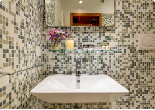Elegante bagno del Palazzo San Firmino a Venezia con pareti in mosaico, lavabo bianco e specchio.