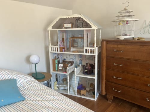 Miniature maison exposée dans la chambre du gîte aux Gîtes De L'odet, Clohars-Fouesnant avec commode en bois et lampe de chevet