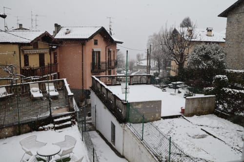 Terrazza e cortile innevati dell'appartamento THE V Collection a Sormano con vista sulle montagne e architettura italiana