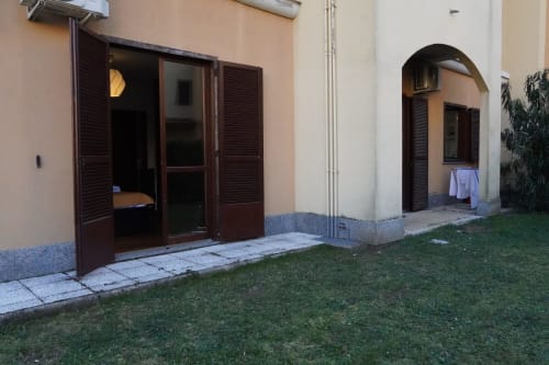 Vista giardino dell'Appartamento Roma 2 presso THE V Collection a Turate con porte in legno scuro e patio privato