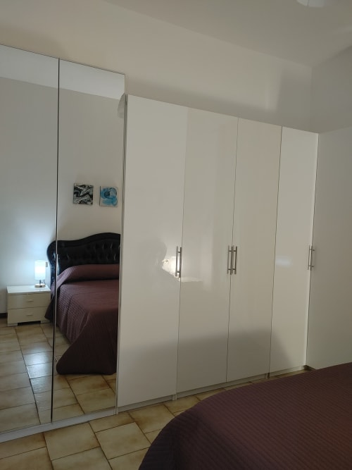 Camera moderna con armadio specchiato e pavimentazione in piastrelle nell'Appartamento Mazzini, hotel THE V Collection a Turate