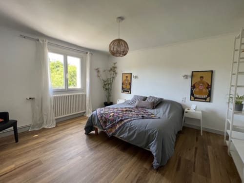 Chambre lumineuse aux Gîtes De L'odet avec lit queen-size, vue jardin, luminaire suspendu et mobilier moderne