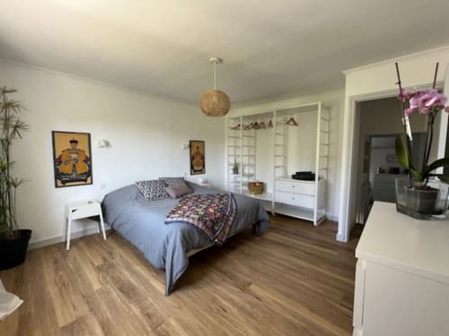 Chambre spacieuse aux Gîtes De L'odet avec lit queen, armoires blanches, vue sur le jardin et équipements modernes
