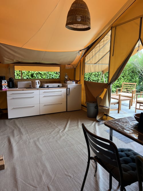 Intérieur du gîte Les Gîtes De L'odet à Clohars-Fouesnant : cuisine, salle à manger et vue sur le jardin depuis la terrasse