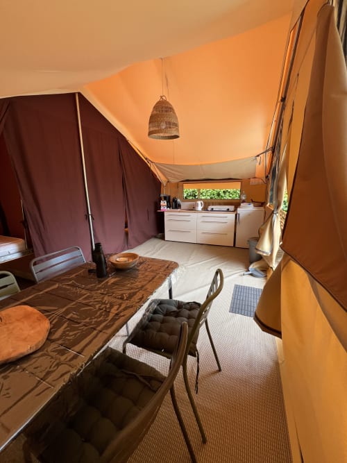 Intérieur spacieux du gîte Les Gîtes De L'odet avec plafond en toile orange, salon confortable et kitchenette