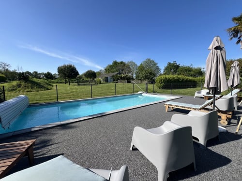 Piscine de villégiature avec transats et parasols aux Gîtes De L'odet, Clohars-Fouesnant, vue sur jardins verdoyants