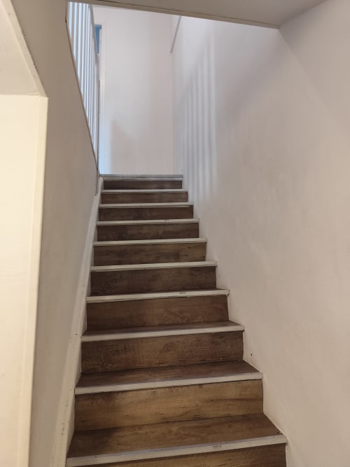 Escalier en bois avec murs blancs menant vers le haut à l'appartement Accolade, Châteaudun