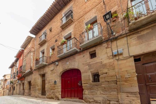 Bâtiment historique Casa Peregrinando à Navarrete en Espagne avec porte rouge et étage en brique