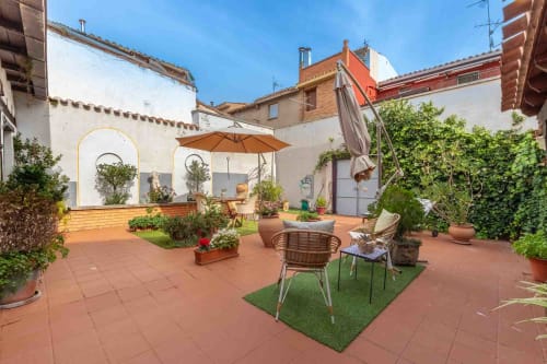 Terrasse sur le toit en terre cuite de la Casa Peregrinando à Navarrete, avec sièges, parasol et plantes en pots