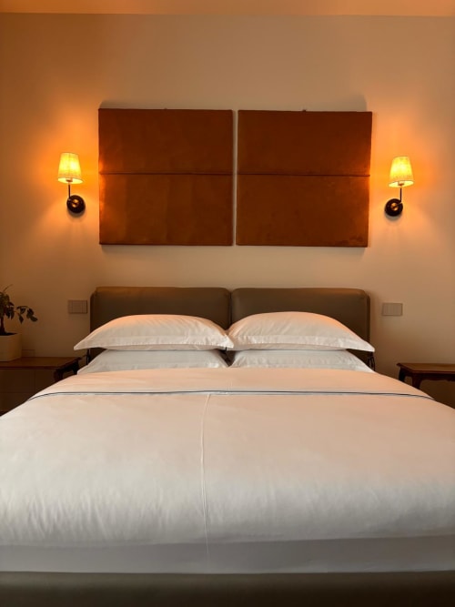 Elegante camera d'hotel al B&B Delta Majestic di Pordenone con testata marrone, biancheria bianca e applique calde
