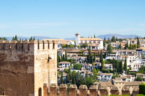 Medieval fortress overlooking Granada's white buildings and cypress trees, Armilla