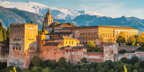 Alhambra palace Granada with snow-capped Sierra Nevada mountains backdrop and historic fortress architecture